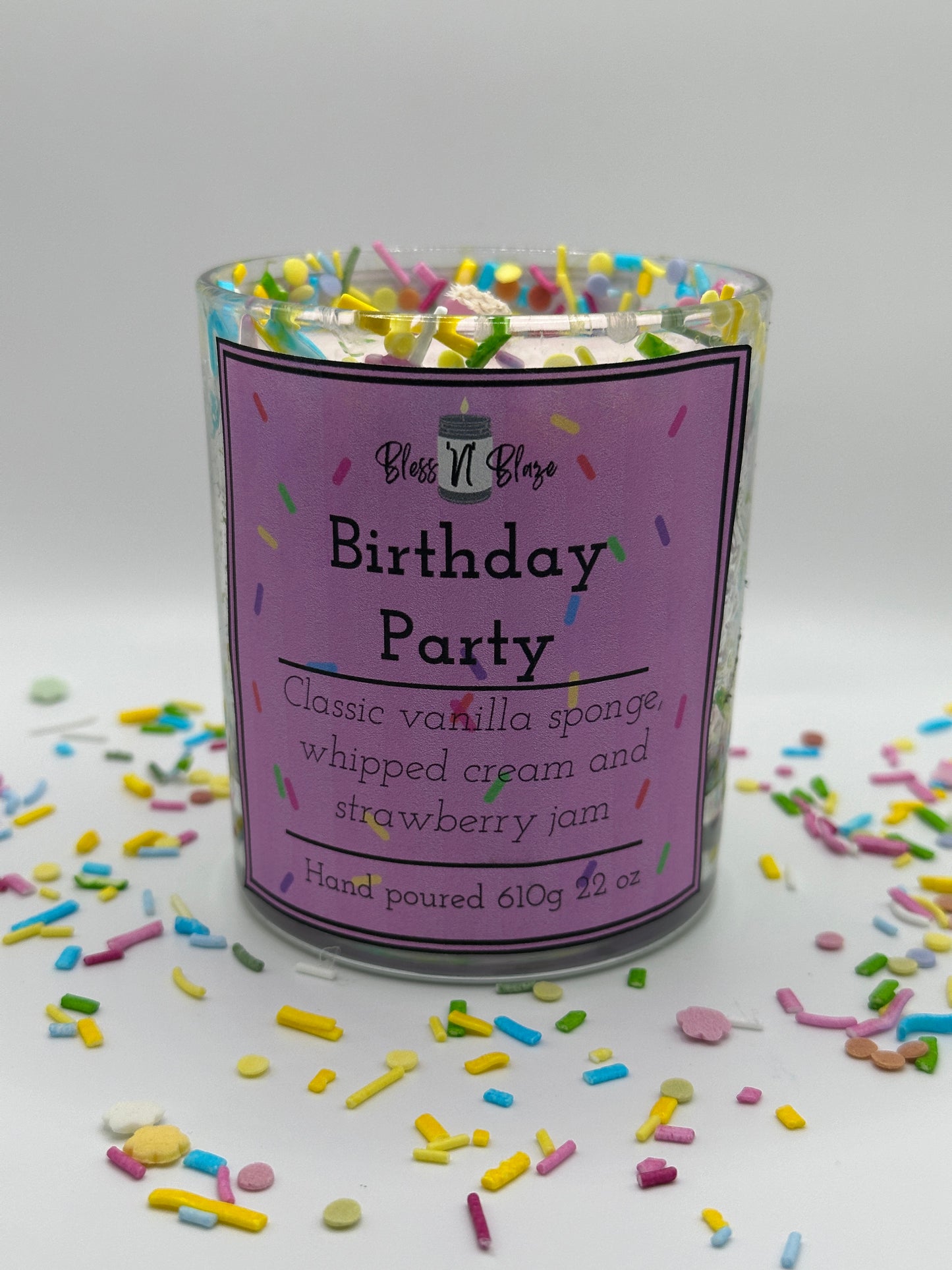 Packaged product with a purple label surrounded by colorful sprinkles on a white background